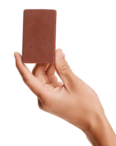 Image of a model holding a bar of Antü Restoring Soap